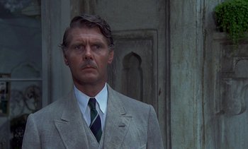 Movie still from “A Passage to India” (1984), directed by David Lean – A person wearing a suit and tie; Close Up shot, Low angle