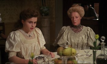 Movie still from “A Room with a View” (1985), directed by James Ivory – Two women sitting at a dinner table with pears on the table; Medium shot, Over the shoulder angle