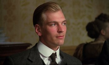Movie still from “A Room with a View” (1985), directed by James Ivory – A man wearing a suit and tie looking to his left; Close Up shot, Low angle