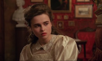 Movie still from “A Room with a View” (1985), directed by James Ivory – A young woman in a white dress looking at the camera; Close Up shot, Over the shoulder angle