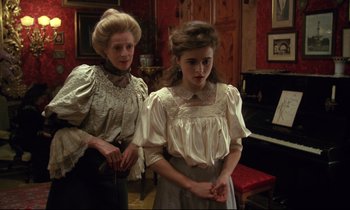 Movie still from “A Room with a View” (1985), directed by James Ivory – A woman and a young girl standing next to each other in a room; Medium shot, High angle