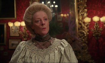 Movie still from “A Room with a View” (1985), directed by James Ivory – A woman in a white dress with a long blonde wig; Close Up shot, Over the shoulder angle