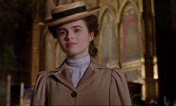 Movie still from “A Room with a View” (1985), directed by James Ivory – A young woman in a straw hat and a coat; Close Up shot, Low angle