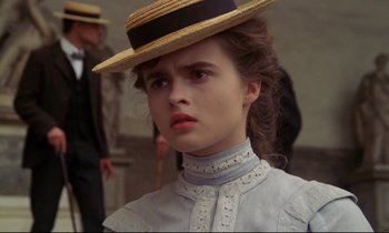 Movie still from “A Room with a View” (1985), directed by James Ivory – A young woman wearing a straw hat and a dress; Close Up shot, Over the shoulder angle