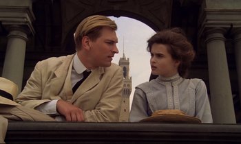 Movie still from “A Room with a View” (1985), directed by James Ivory – A man and a woman sitting next to each other; Medium shot, Low angle