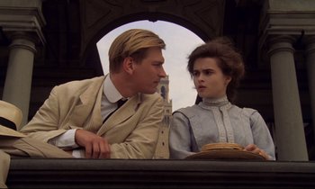 Movie still from “A Room with a View” (1985), directed by James Ivory – A man and a woman sitting next to each other; Medium shot, Low angle