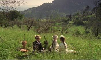 Movie still from “A Room with a View” (1985), directed by James Ivory – A group of people sitting in the grass; Extreme Wide shot, High angle