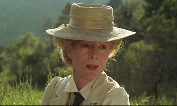 Movie still from “A Room with a View” (1985), directed by James Ivory – An older woman wearing a straw hat and a tie; Close Up shot, Low angle