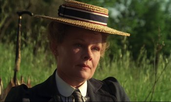 Movie still from “A Room with a View” (1985), directed by James Ivory – An older woman wearing a straw hat in a grassy area; Close Up shot, Low angle