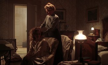 Movie still from “A Room with a View” (1985), directed by James Ivory – Two women in a room with a lamp on the floor; Medium shot, High angle