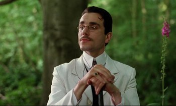 Movie still from “A Room with a View” (1985), directed by James Ivory – A man in a white suit and tie looking up; Close Up shot, Low angle