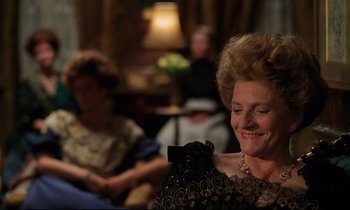 Movie still from “A Room with a View” (1985), directed by James Ivory – An older woman is smiling while holding a camera; Close Up shot, Over the shoulder angle