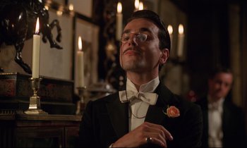 Movie still from “A Room with a View” (1985), directed by James Ivory – A man in a suit and bow tie; Close Up shot, Low angle