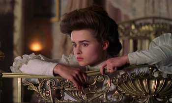 Movie still from “A Room with a View” (1985), directed by James Ivory – A young woman in a white dress sitting in a chair; Close Up shot, Low angle