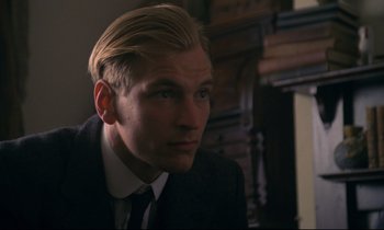 Movie still from “A Room with a View” (1985), directed by James Ivory – A person wearing a suit and tie; Close Up shot, Over the shoulder angle