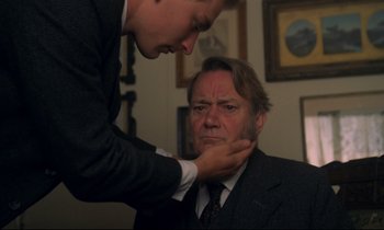Movie still from “A Room with a View” (1985), directed by James Ivory – A man in a business suit and a man in a suit and tie; Close Up shot, Over the shoulder angle
