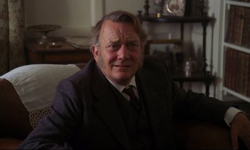 Movie still from “A Room with a View” (1985), directed by James Ivory – An older man wearing a suit and a tie; Close Up shot, Low angle