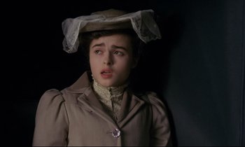 Movie still from “A Room with a View” (1985), directed by James Ivory – A young woman wearing a coat and a hat; Close Up shot, High angle