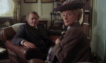Movie still from “A Room with a View” (1985), directed by James Ivory – A man and a woman sitting in a chair; Medium shot, Low angle