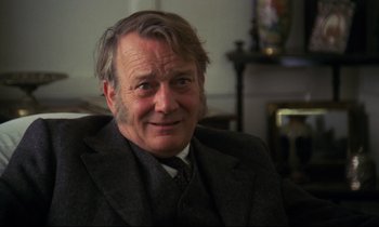 Movie still from “A Room with a View” (1985), directed by James Ivory – An older man wearing a suit and a tie; Close Up shot, Over the shoulder angle
