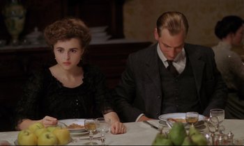 Movie still from “A Room with a View” (1985), directed by James Ivory – A man and a woman sitting at a dinner table; Medium shot, High angle