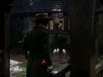 Movie still from “A Song to Remember” (1945), directed by Charles Vidor – A man in a green coat and a brown hat looking out of a window; Wide shot, Over the shoulder angle
