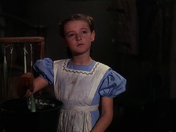Movie still from “A Song to Remember” (1945), directed by Charles Vidor – A young girl in an apron standing next to a table; Close Up shot, Low angle