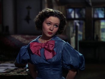 Movie still from “A Song to Remember” (1945), directed by Charles Vidor – A woman in a blue dress with a pink bow; Close Up shot, Over the shoulder angle
