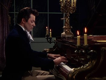 Movie still from “A Song to Remember” (1945), directed by Charles Vidor – A man sitting at a piano in front of candles; Medium shot, High angle