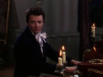 Movie still from “A Song to Remember” (1945), directed by Charles Vidor – A man holding a candle in front of a table; Medium shot, High angle