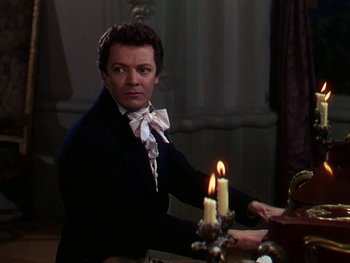 Movie still from “A Song to Remember” (1945), directed by Charles Vidor – A man sitting at a table with a candle in front of him; Medium shot, Over the shoulder angle