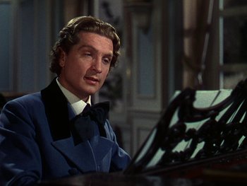 Movie still from “A Song to Remember” (1945), directed by Charles Vidor – A man sitting at a piano wearing a blue suit and black bow tie; Close Up shot, High angle