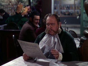 Movie still from “A Song to Remember” (1945), directed by Charles Vidor – A man with a long beard sitting at a table looking at a menu; Medium shot, Over the shoulder angle