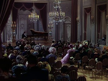 Movie still from “A Song to Remember” (1945), directed by Charles Vidor – A group of people sitting in a room with a grand piano; Extreme Wide shot, High angle