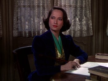 Movie still from “A Song to Remember” (1945), directed by Charles Vidor – A woman sitting at a table in front of papers; Medium shot, High angle