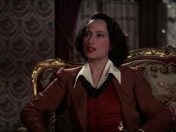 Movie still from “A Song to Remember” (1945), directed by Charles Vidor – A woman sitting in a chair wearing a suit; Close Up shot, High angle