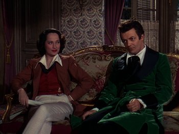 Movie still from “A Song to Remember” (1945), directed by Charles Vidor – A man and a woman sitting on a couch in a room; Medium shot, High angle