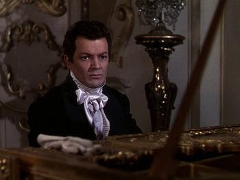 Movie still from “A Song to Remember” (1945), directed by Charles Vidor – A man sitting at a table wearing a suit and tie; Medium shot, High angle