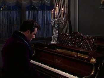 Movie still from “A Song to Remember” (1945), directed by Charles Vidor – A man is playing a piano in a room with candles; Medium shot, High angle