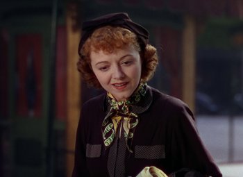 Movie still from “A Star Is Born” (1937), directed by Victor Fleming – A red headed woman wearing a hat and a scarf; Close Up shot, Low angle