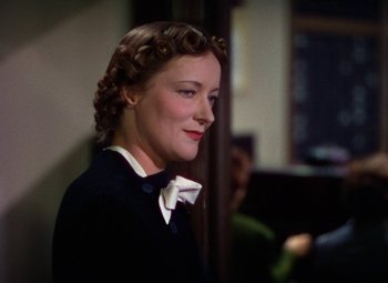 Movie still from “A Star Is Born” (1937), directed by Victor Fleming – A person wearing a suit and a bow tie; Close Up shot, Low angle