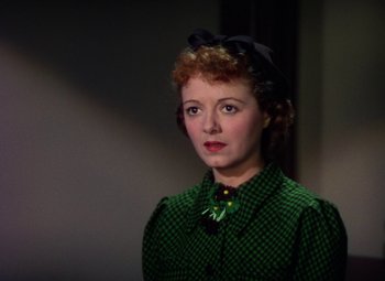Movie still from “A Star Is Born” (1937), directed by Victor Fleming – A woman with red hair wearing a green shirt and a black bow tie; Close Up shot, Low angle