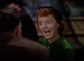 Movie still from “A Star Is Born” (1937), directed by Victor Fleming – A woman in a green shirt is looking surprised; Close Up shot, Over the shoulder angle