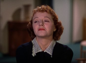 Movie still from “A Star Is Born” (1937), directed by Victor Fleming – A woman with red curly hair and a black sweater; Close Up shot, High angle