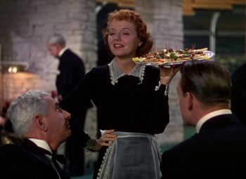 Movie still from “A Star Is Born” (1937), directed by Victor Fleming – A woman holding a tray of food in front of two other people; Medium shot, Over the shoulder angle