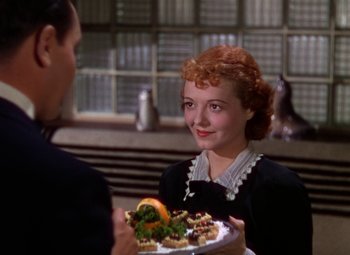 Movie still from “A Star Is Born” (1937), directed by Victor Fleming – A woman is holding a plate of food in front of a man; Close Up shot, High angle