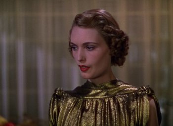 Movie still from “A Star Is Born” (1937), directed by Victor Fleming – A woman in a gold dress looking to her left; Close Up shot, Low angle