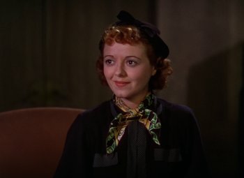 Movie still from “A Star Is Born” (1937), directed by Victor Fleming – A woman wearing a hat and a bow tie; Close Up shot, High angle