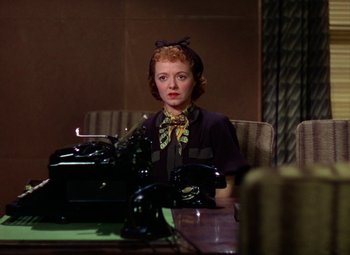Movie still from “A Star Is Born” (1937), directed by Victor Fleming – A woman sitting in front of an old fashioned typewriter; Medium shot, High angle