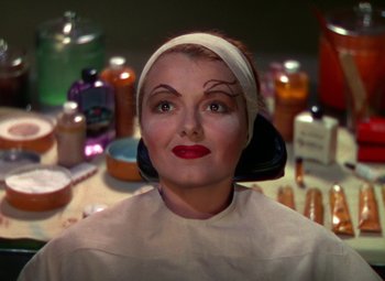 Movie still from “A Star Is Born” (1937), directed by Victor Fleming – A woman sitting in front of a bunch of bottles; Close Up shot, Over the shoulder angle